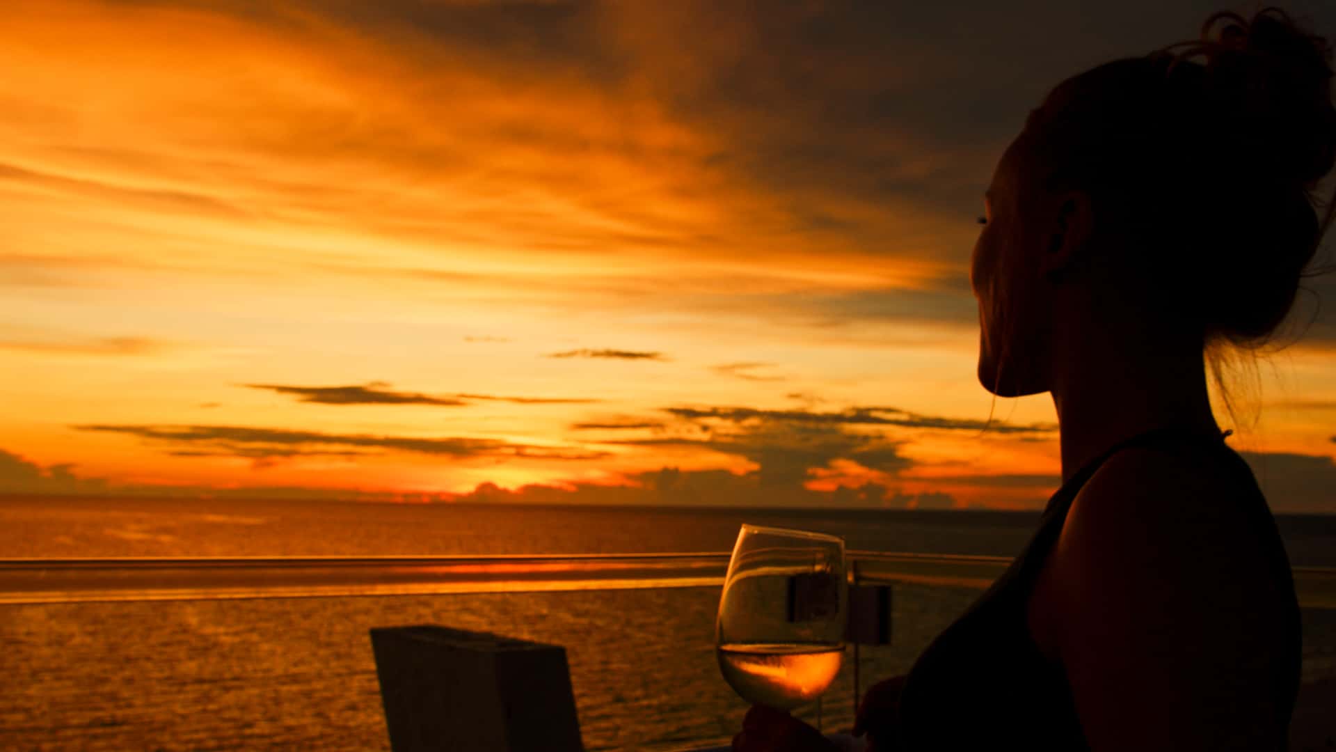 Silhouette of a woman drinking wine enjoying an amazing sunset over Clearwater Beach, near Riverview