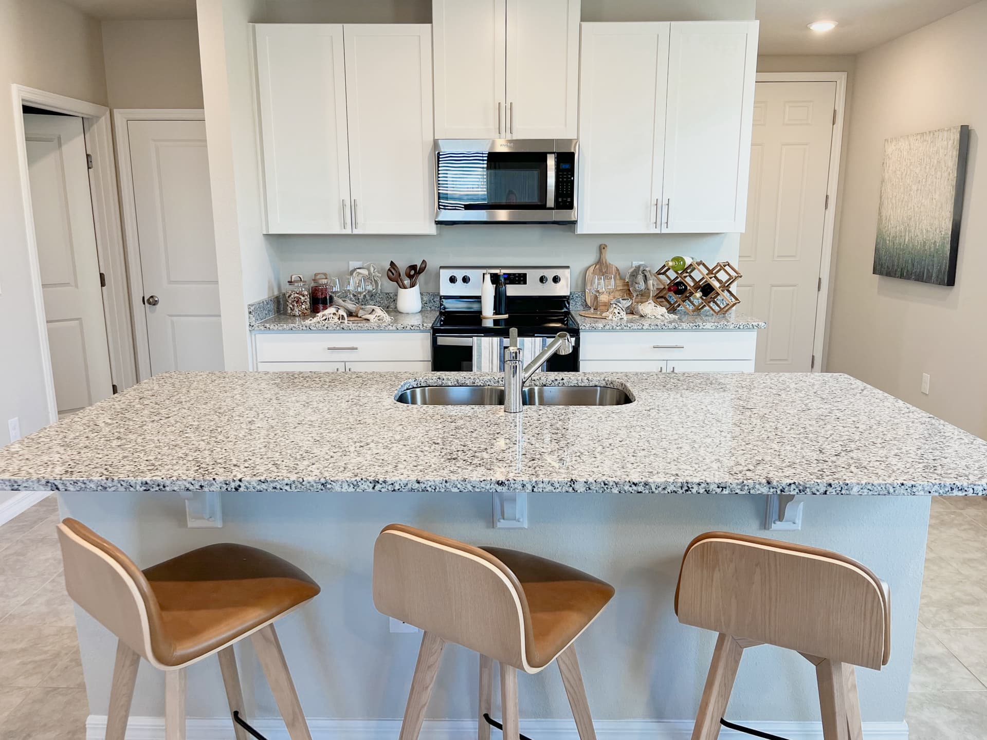 Fully equipped kitchen with large center island featuring sink and countertop seating